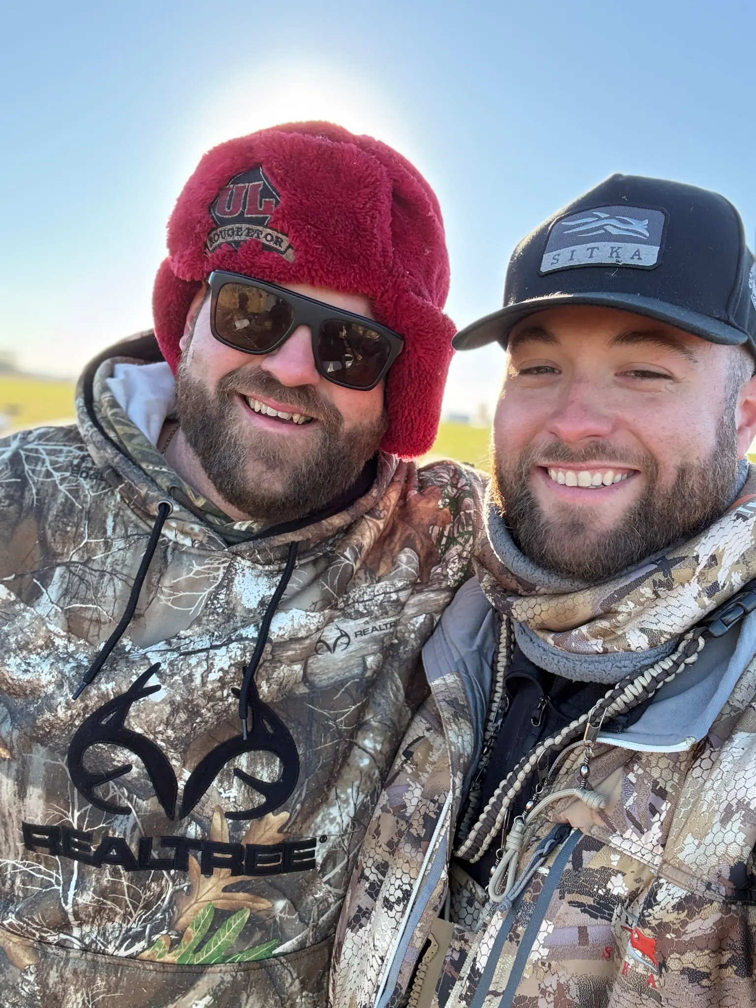 Deux chasseurs en tenue camouflage, sourires au soleil