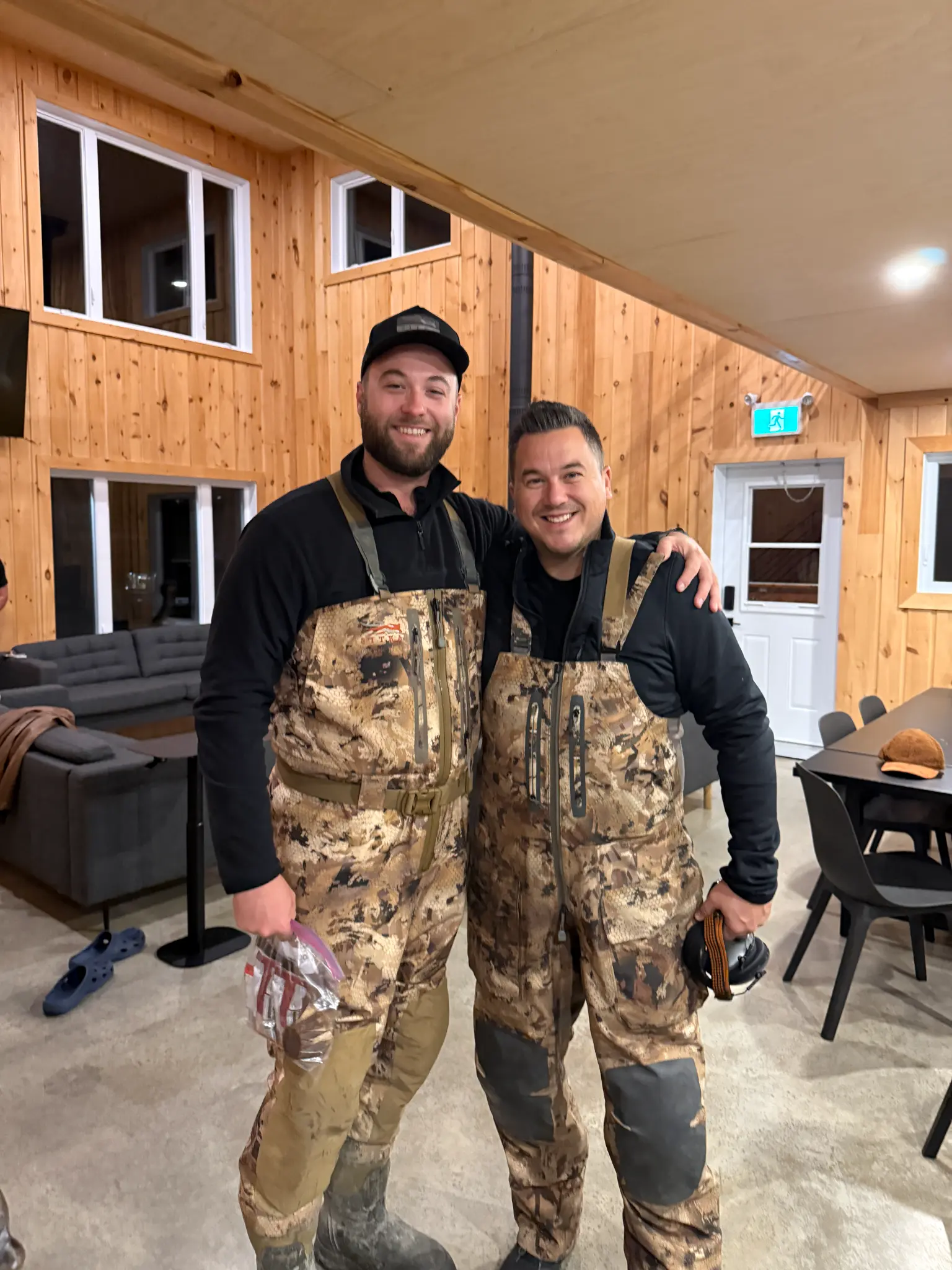 Deux chasseurs en waders dans le grand salon du lodge
