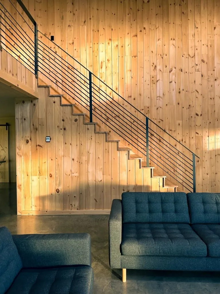 Intérieur du lodge avec escalier en bois et salon